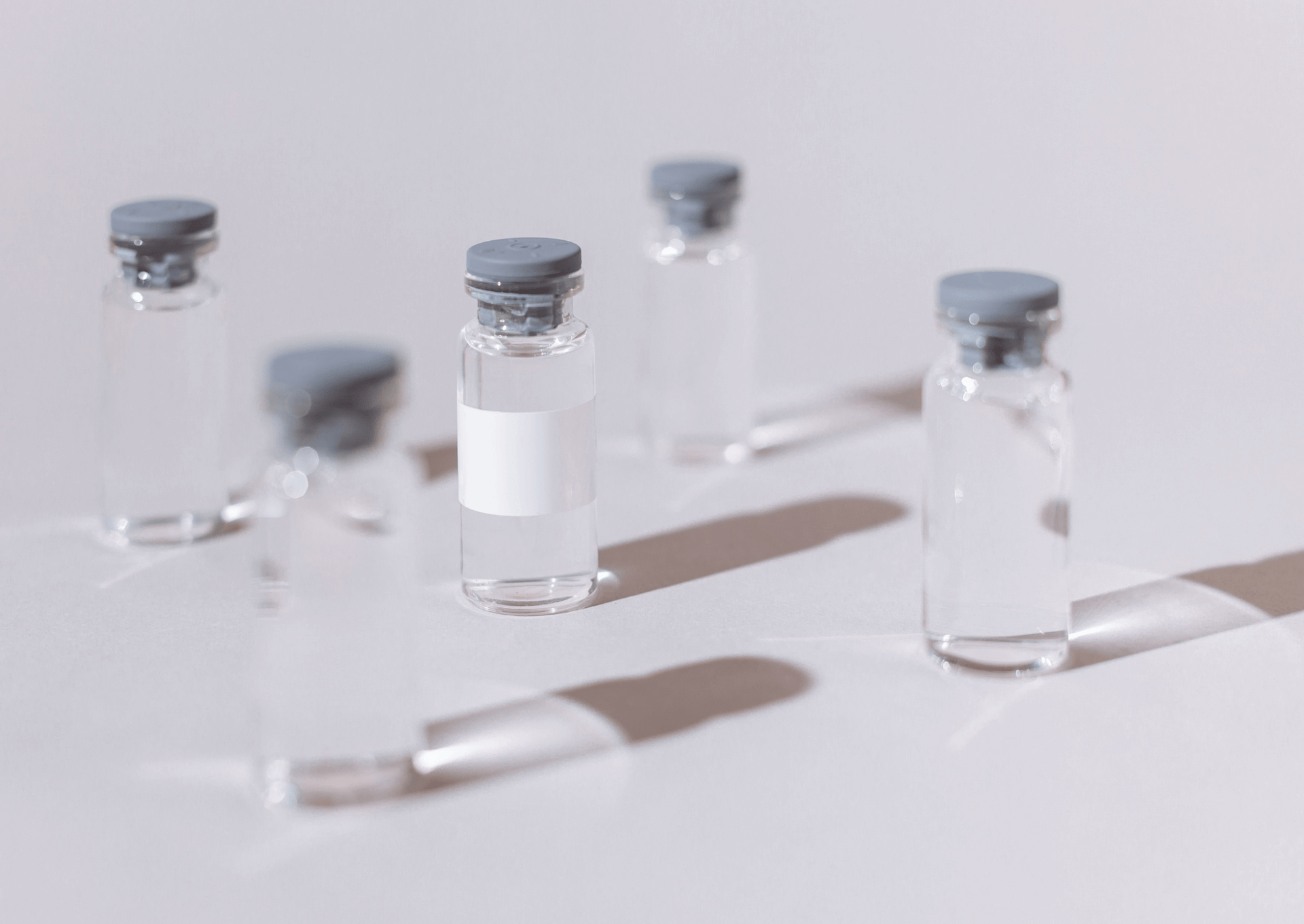 Clear vials with blue caps on a white surface