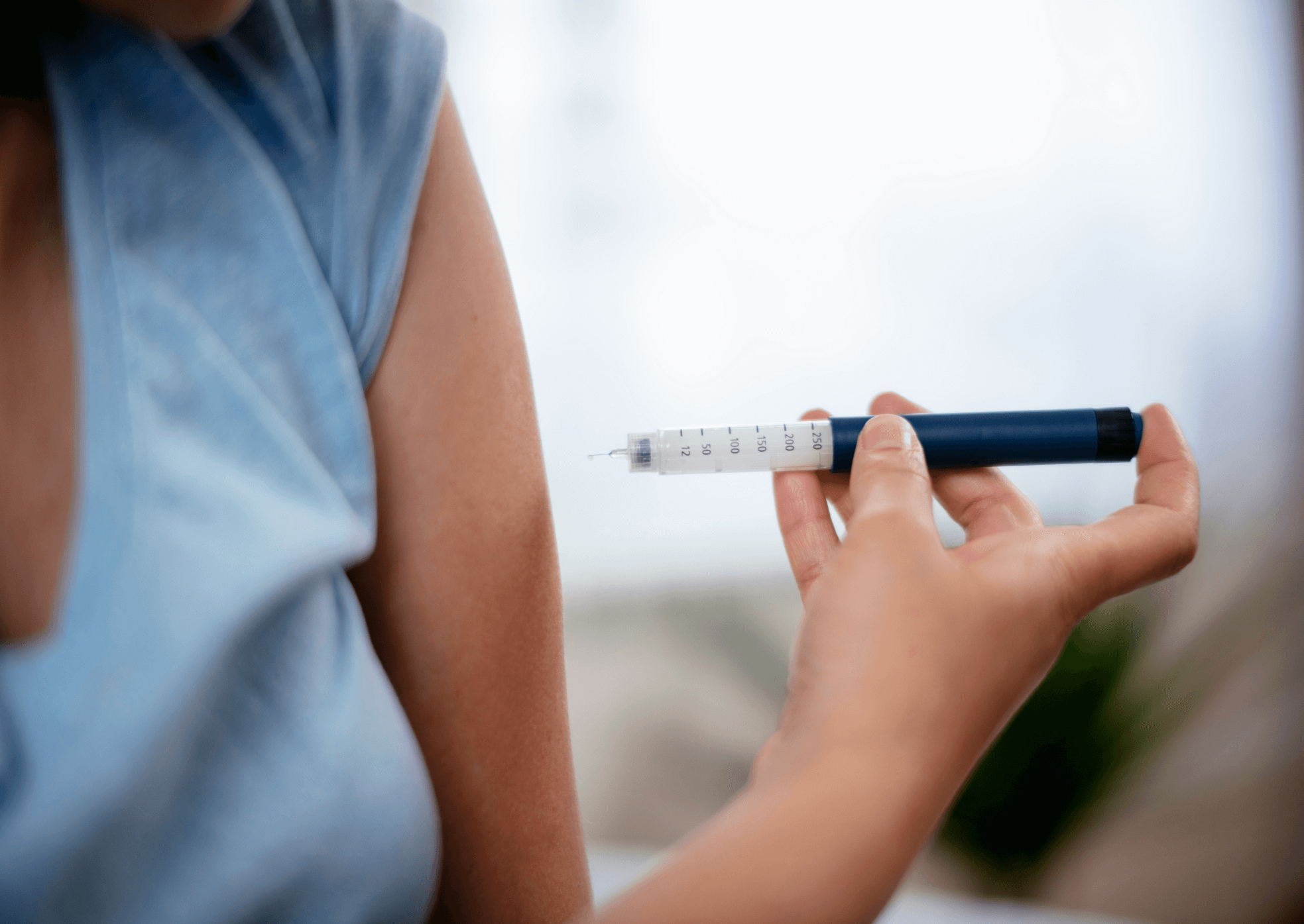 Person holding a syringe with a blurred background